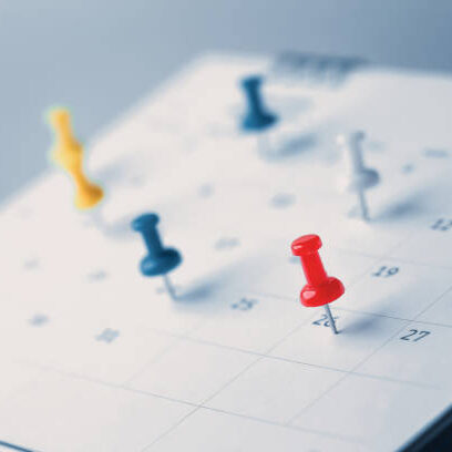 Embroidered red pins on a calendar event Planner calendar,clock to set timetable organize schedule,planning for business meeting or travel planning concept.